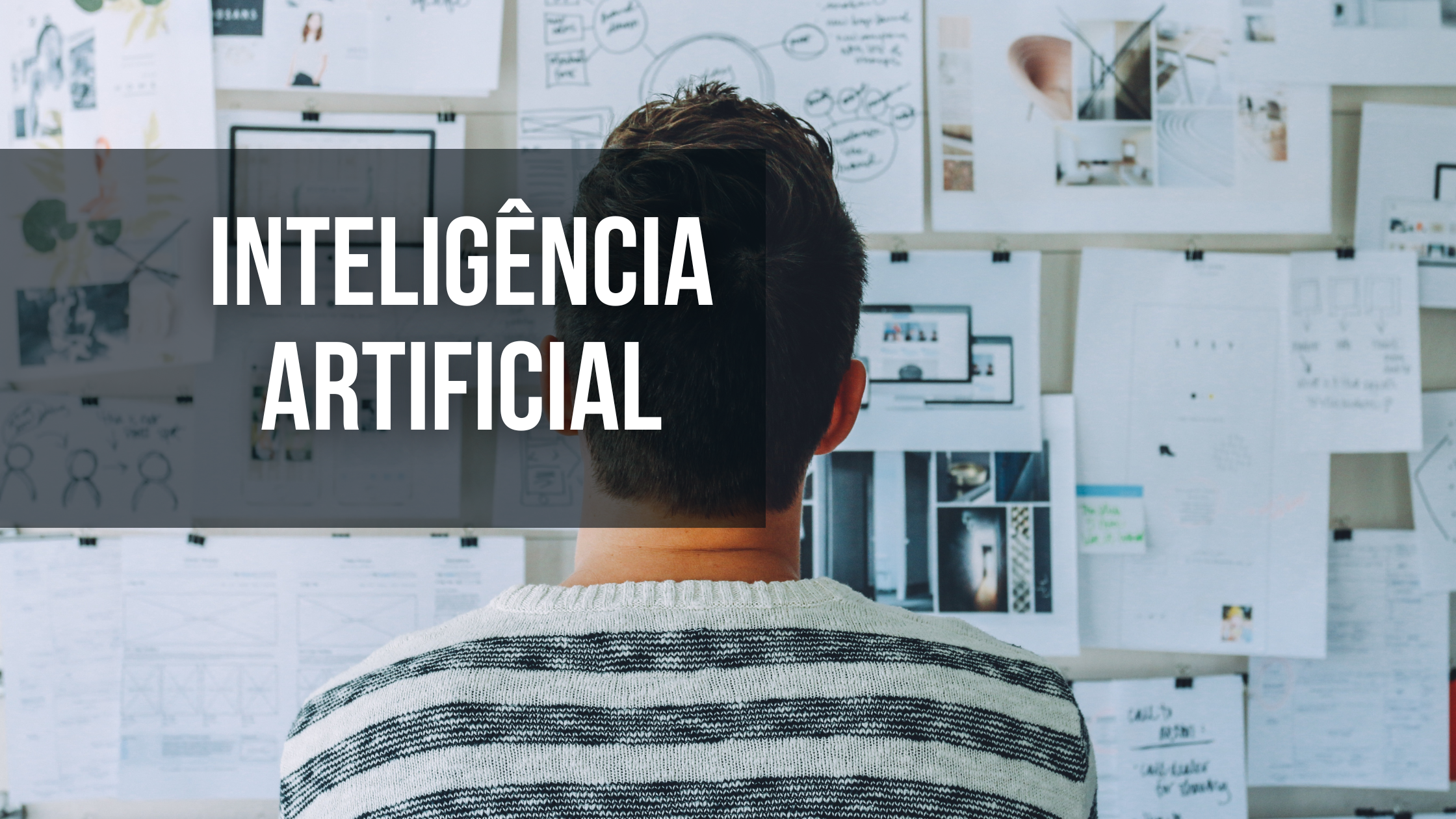 homem em frente a um painel cheio de planilhas com a frase inteligência artificial.